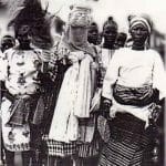Uma sacerdotisa da divindade Are é acompanhada por um mascarado que a honra retratando seu papel ritual. Ilaro, 1978.