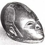 A cabeça cuidadosamente raspada, na qual se vê , ao centro, um tufo de cabelo, ladeado por um tufo circular com um rabo-de-cavalo, identificada uma devota de uma divindade iorubá. British Museum, London, 1959.