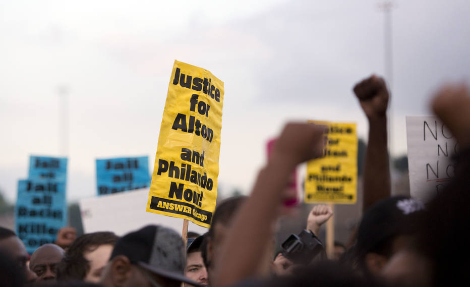 Protestors march in front of Police District 2 Station in Chicago on July 2016 after the video Alton Sterling being killed by Baton Rouge Police Department was released last night. Black motorist Philando Castile, 32, a school cafeteria worker, was shot at close range by a Minnesota cop and seen bleeding to death in a graphic video shot by his girlfriend that went viral Thursday, the second fatal police shooting to rock America in as many days. / AFP PHOTO / Tasos Katopodis