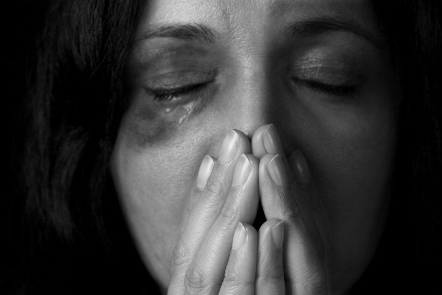 Mulher ferida e com a mão na boca feminicídio e violência