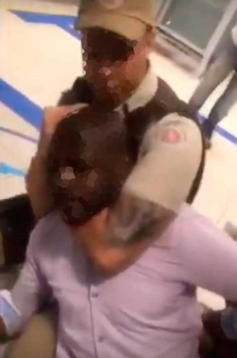 um policial imobilizando um homem negro por enforcamento