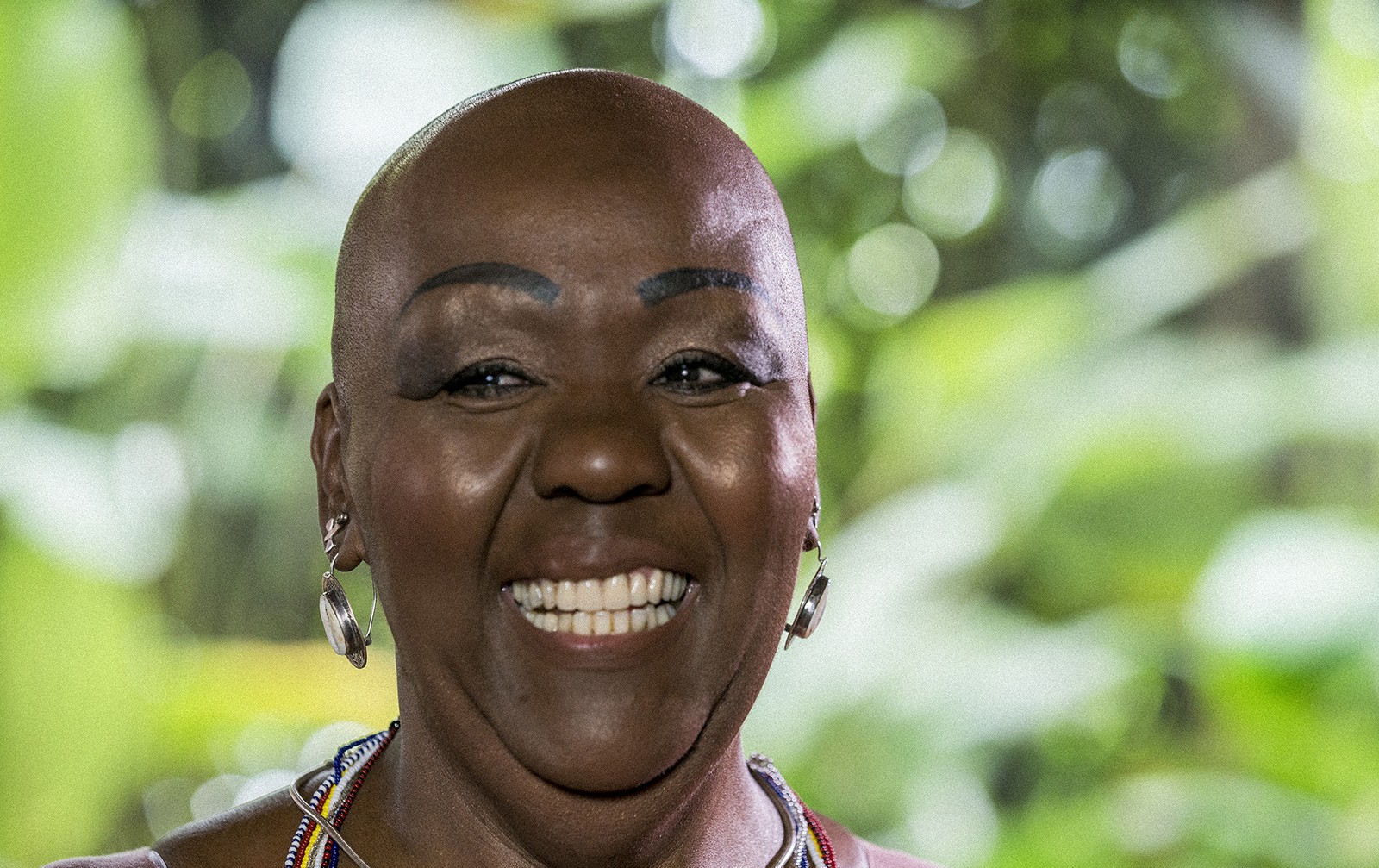Virgínia Rodrigues - mulher negra, careca- em pé sorrindo