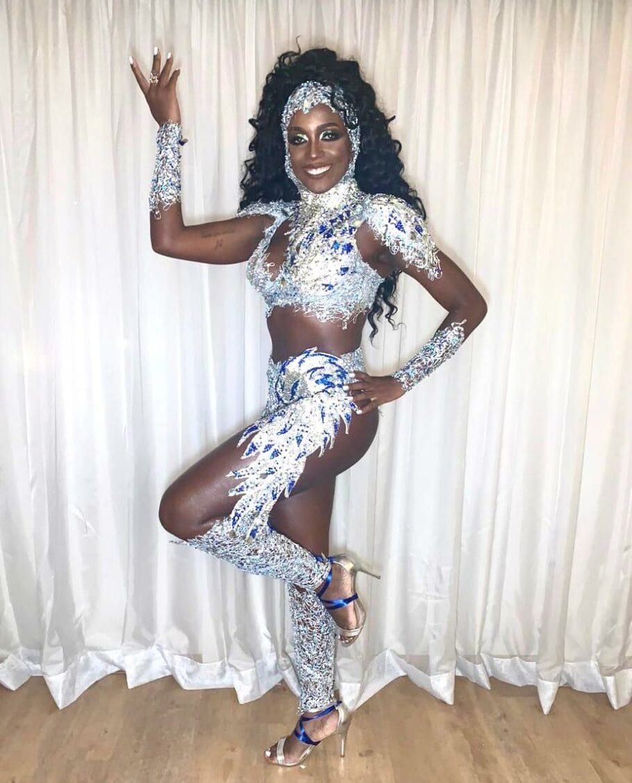 Mayra Barbosa- mulher negra, de cabelo longo e ondulado, caracterizada para o carnaval- em pé fazendo pose